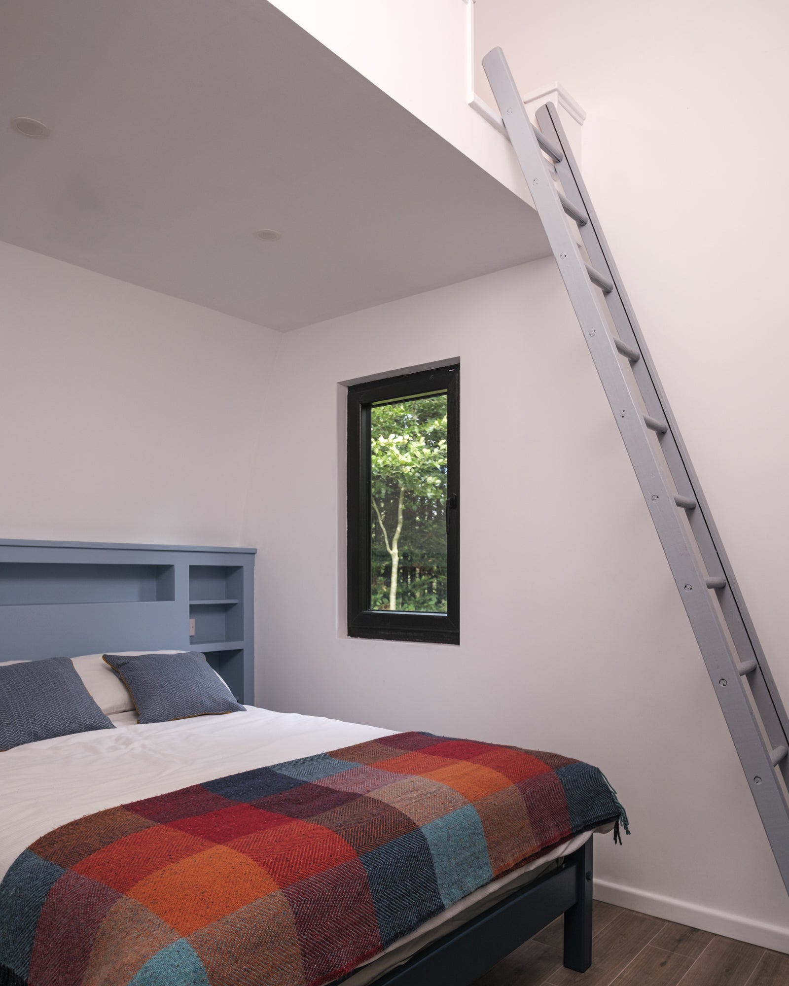 Bedroom of the Aviator Lodge prototype with a ladder to the storage loft.
