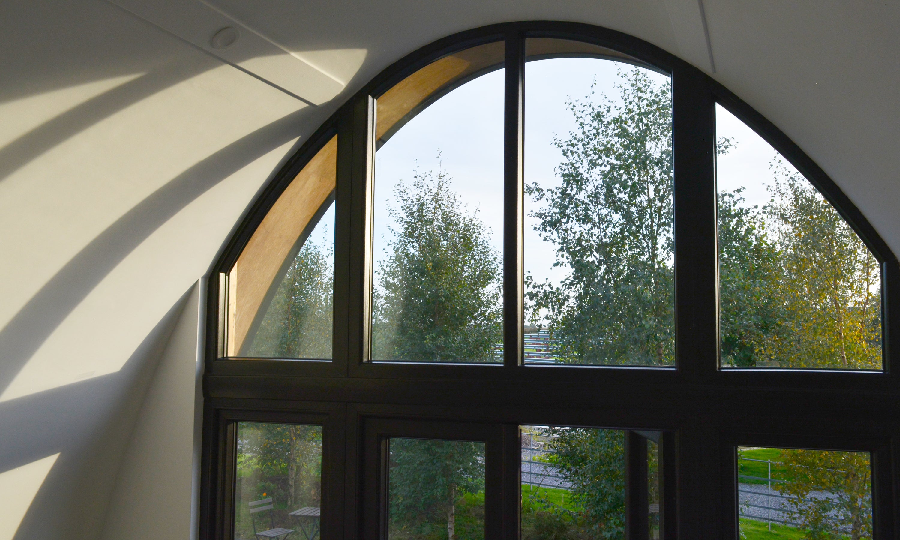 Window detail of the curved roof in the Aviator Lodge. A building design for a modular garden starter home.