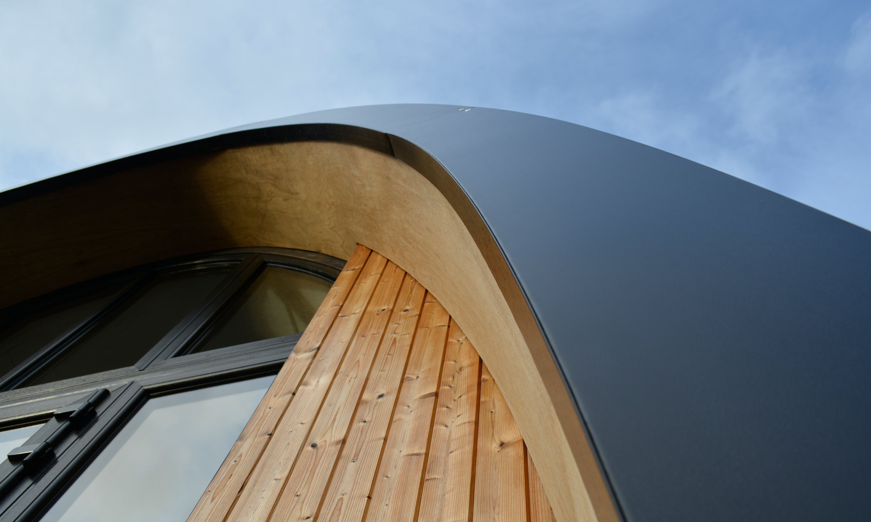 Designer modular home showing the timber wall detail and black metal flashing at the eaves. This is a handmade prefab from Ireland suitable for additional dwelling units in the garden.