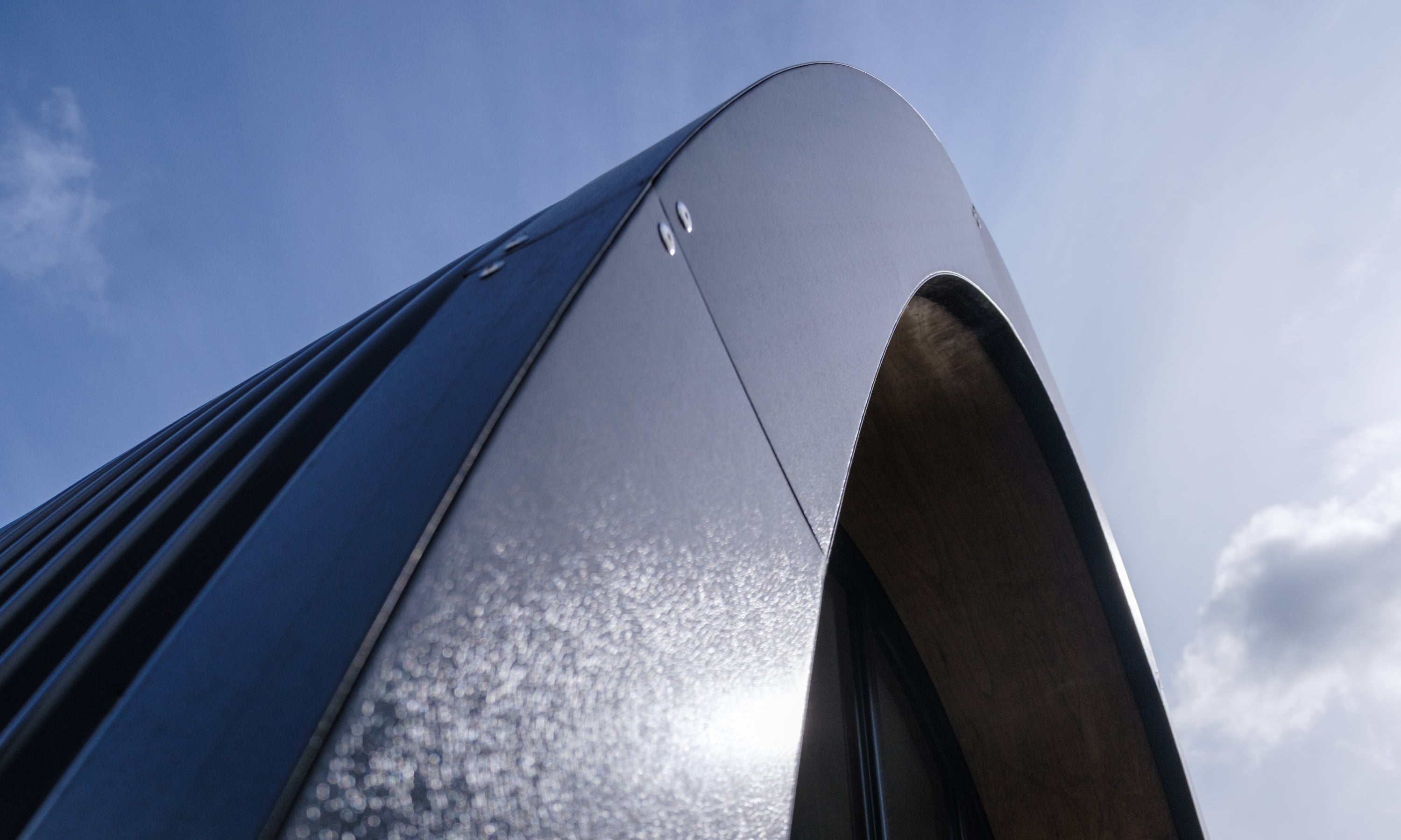 Detail of the curved steel roof flashing of a modular prefab garden home in Ireland.