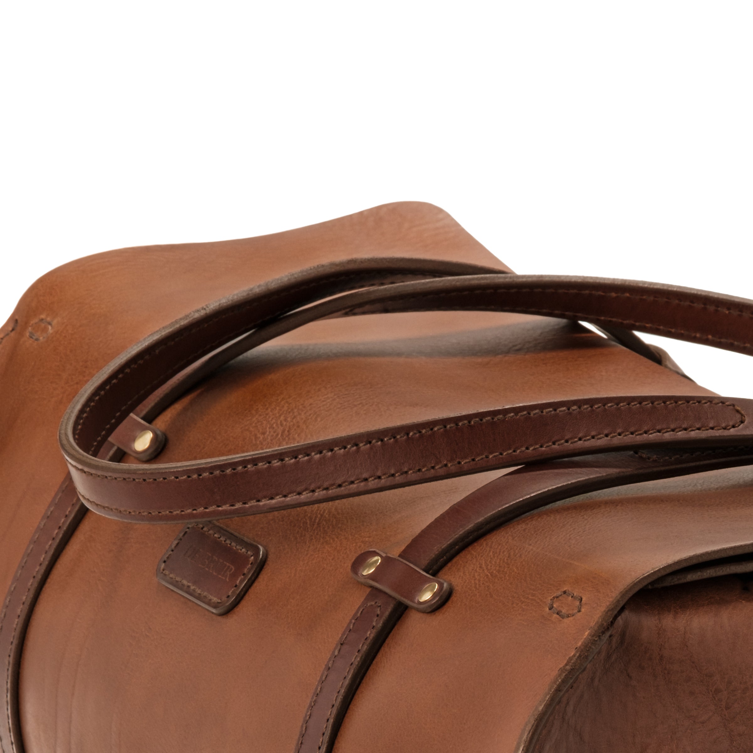 Detail of the character grain of the DE BRUIR Duffle Bag. A cognac colour combines with a chocolate brown to create a vintage two-tone effect.