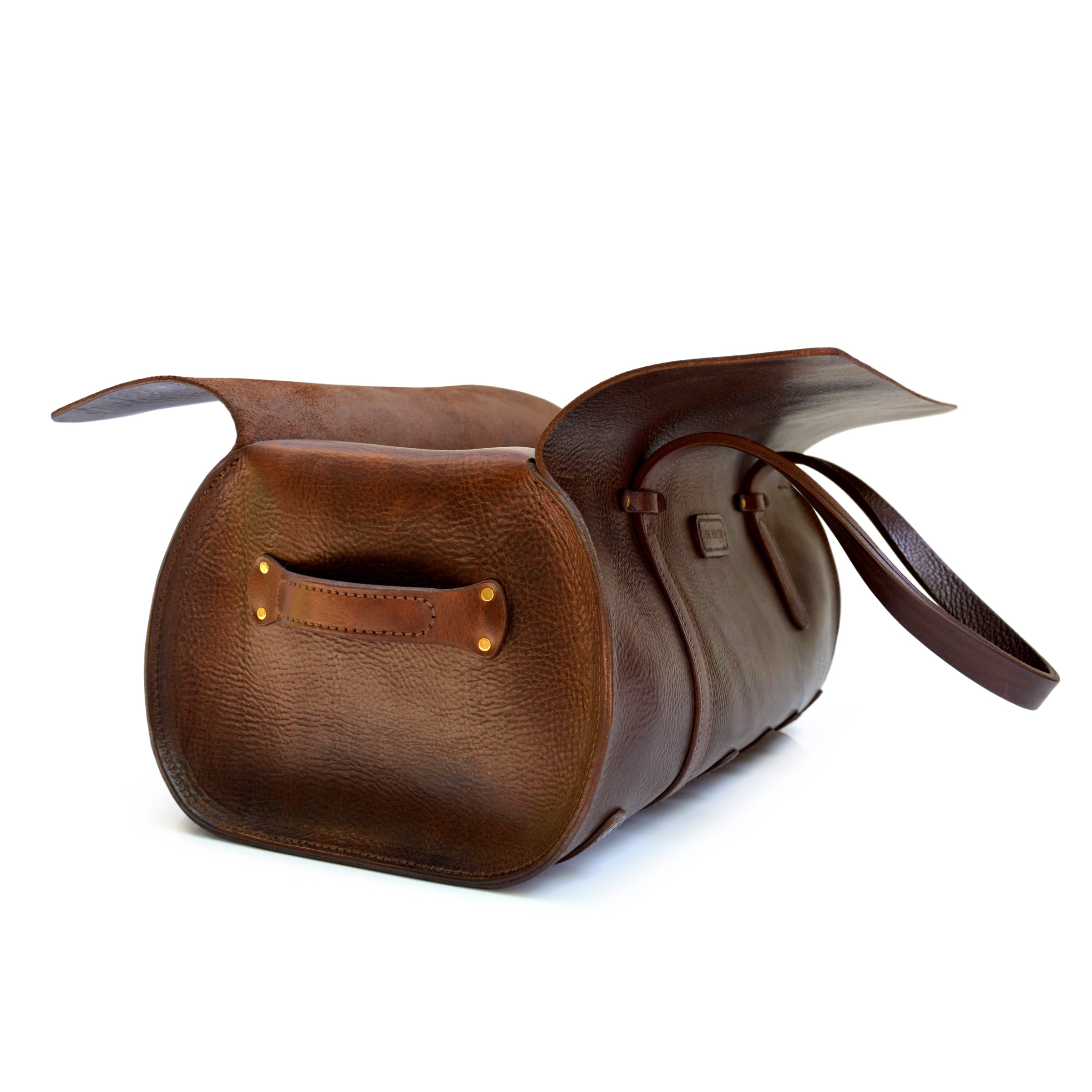 This image captures the simplicity of the Duffle Bag construction. The large wrap of full-grain leather folds back to open. Revealing a spacious interior that is easy to access.