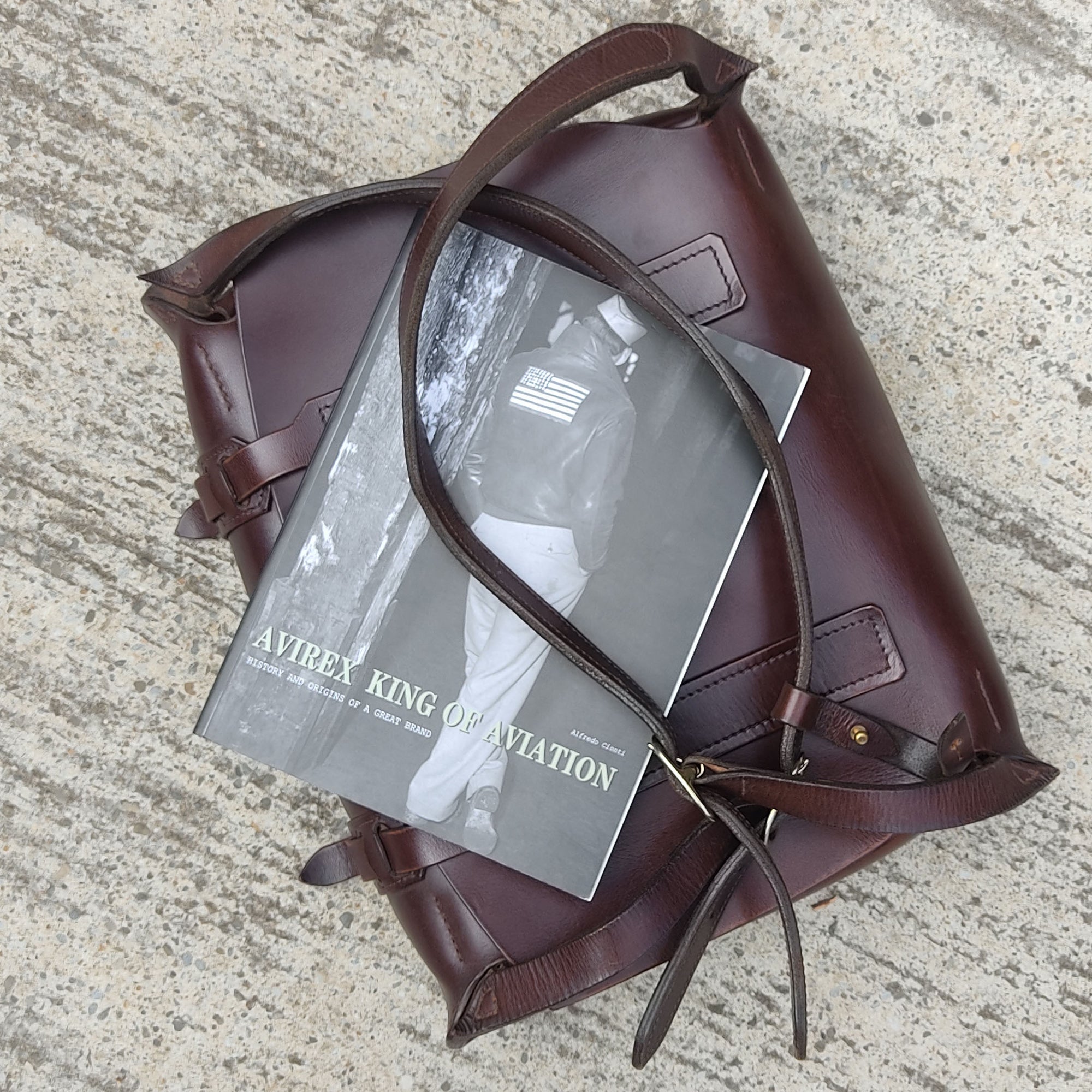 AVIREX King of Aviation, History and Origins of a great brand, book by Alfredo Cionti sitting of a DE BRUIR Parachuter Bag.