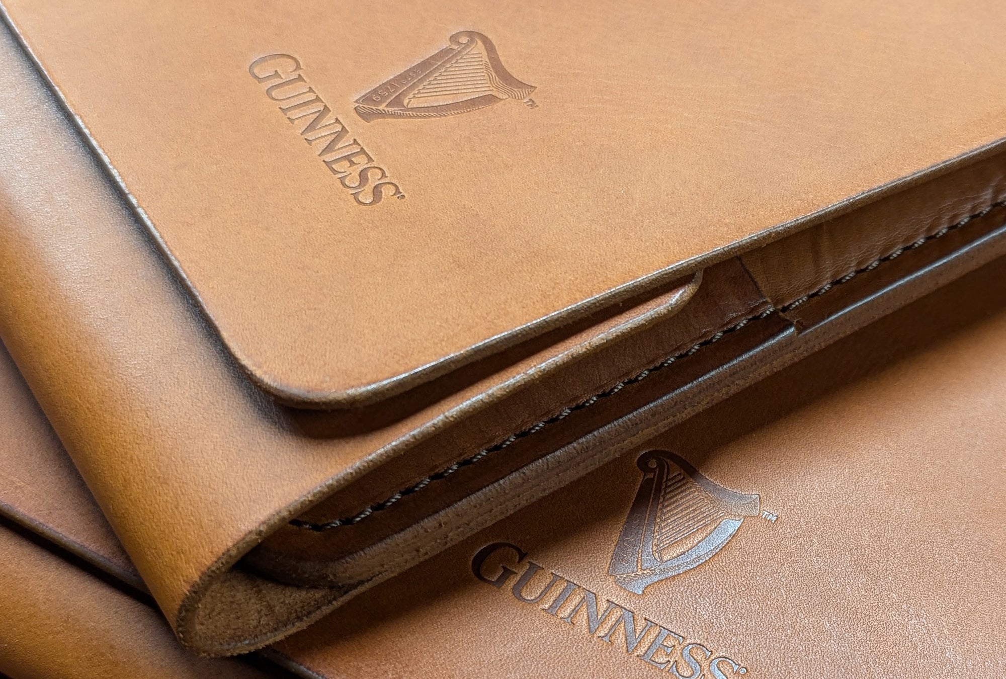 A detail of a leather accessory embossed with the Guinness logo by Garvan de Bruir