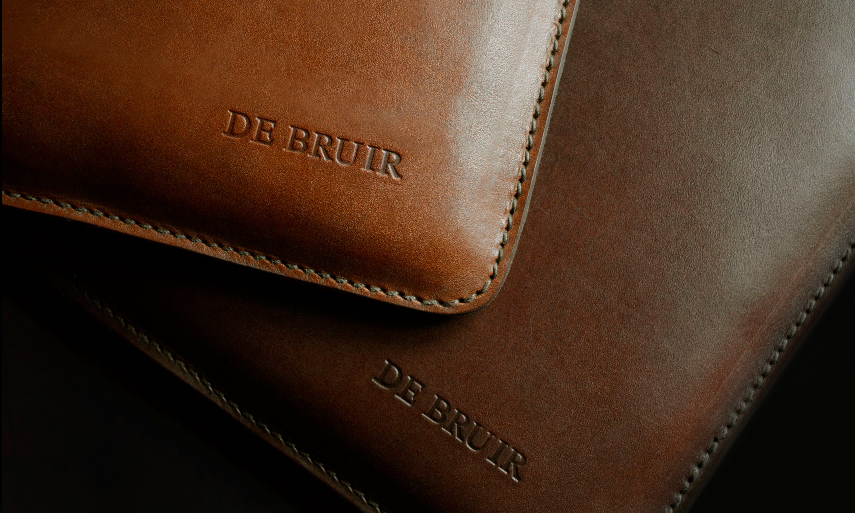 Detail of the DE BRUIR Atelier logo embossed on Garvan de Bruir leather accessories.