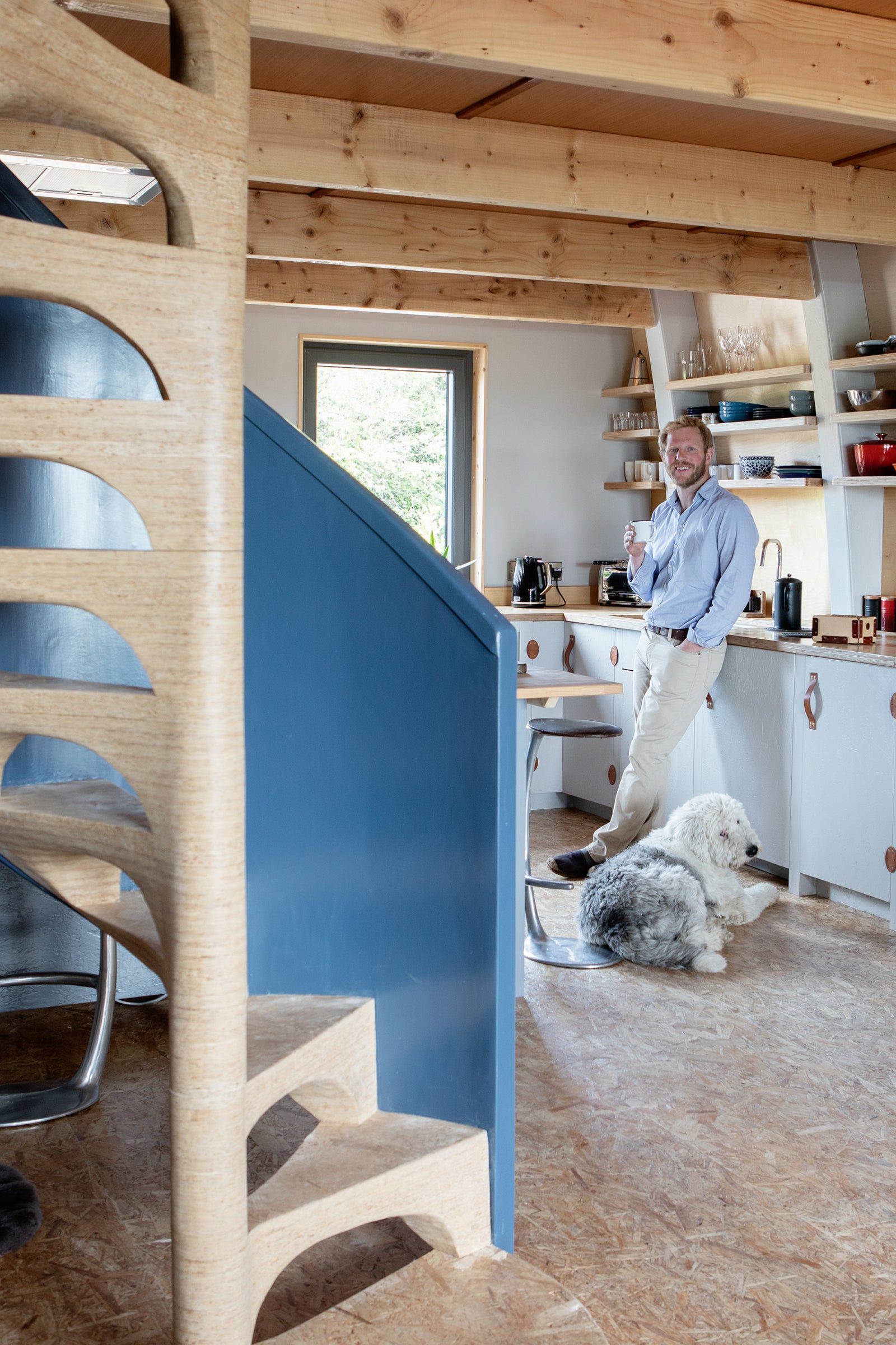 Designer and Craftsman Garvan de Bruir in the kitchen of his Aviator Haus. A concept prefab home that he self built. 
The photo includes the handmade spiral staircase, stack laminated in Smartply OSB.