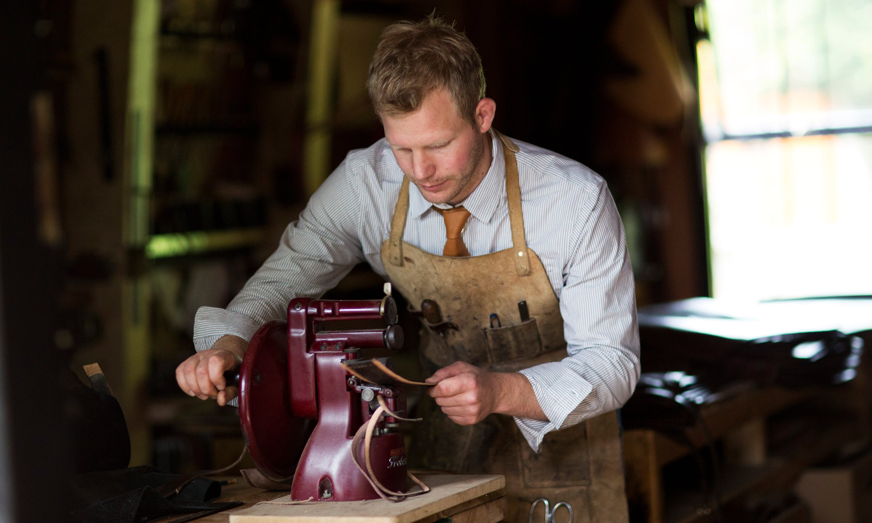 Artisan Garvan de Buir using a Frobaba leather skiving machine to shape pieces of leather at his Atelier in Kildare, Ireland. The leather components are for his exclusive handmade Travel Bags. 