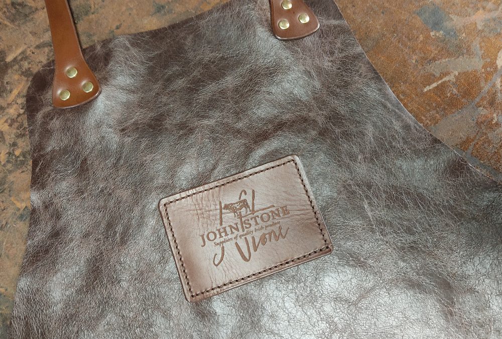 Custom handcrafted full-grain leather apron embossed with John Stone logo for Irish produce supplier, created for hospitality and branded use in Ireland