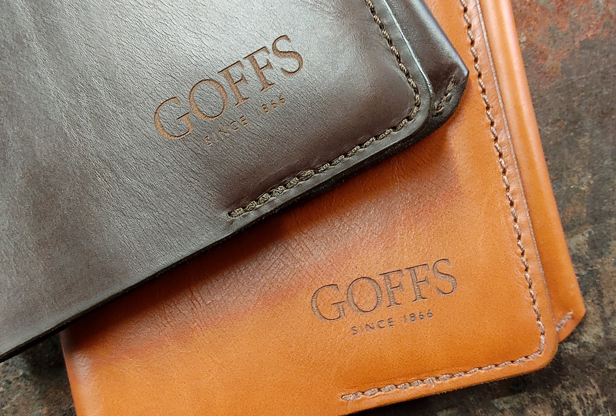 Two leather wallets, one light brown, the other one brown, with 'GOFFS' branding embossed