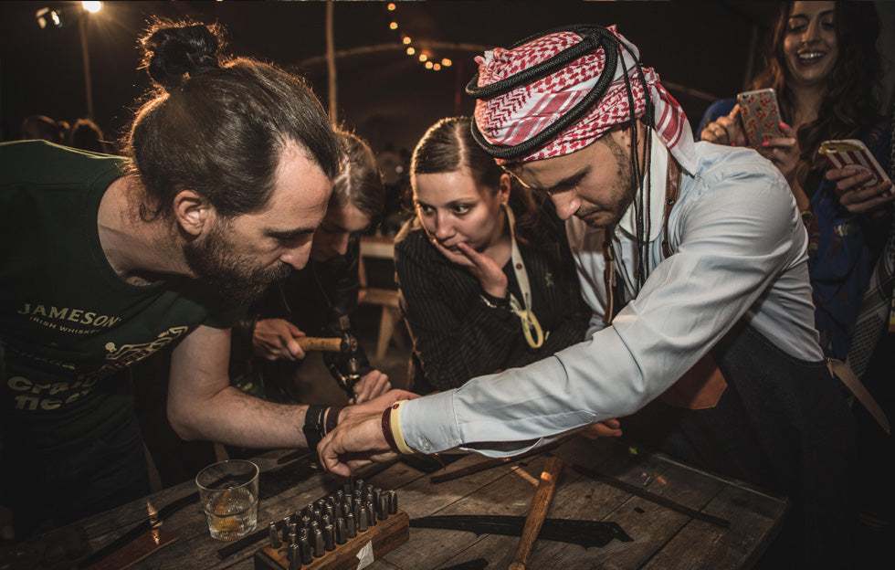 Guests taking part in an interactive leather embossing workshop, creating personalised leather wristbands at a Jameson corporate event in Dublin