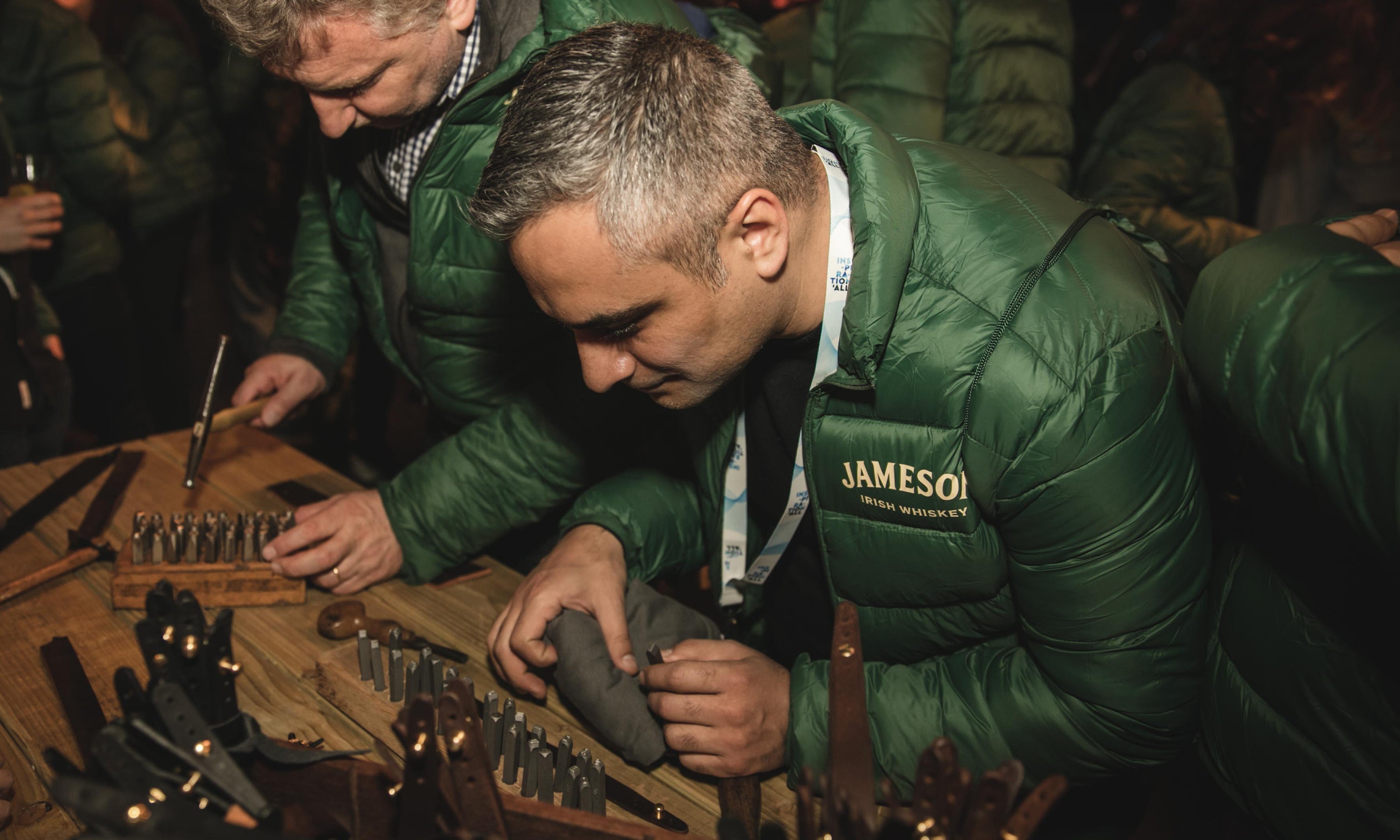 Guests at the Jameson corporate event making personalised leather bracelets with Garvan de Bruir for Middleton black barrel